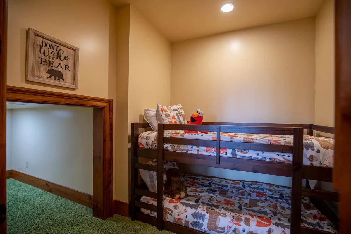 A playful and welcoming bunk nook outfitted with bunk beds, bear-themed decor, and stuffed animals. The cozy setup is ideal for children or groups of friends to enjoy story time, games, or restful sleepovers in a fun environment.